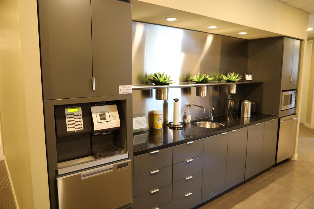 Office kitchen area with stainless steel appliances.